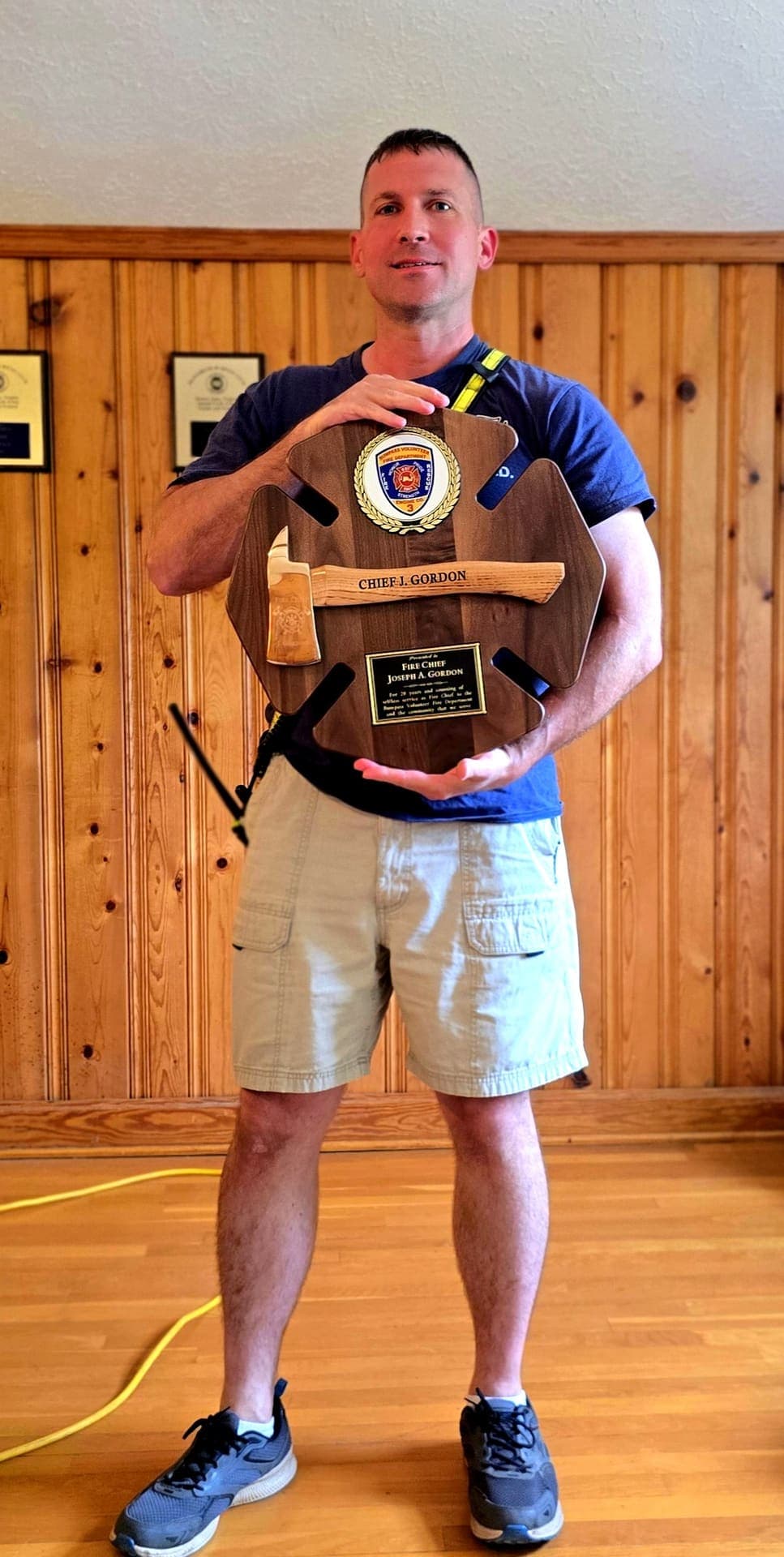 Fire Chief Joseph A. Gordon holding his 20 Years of Service ceremonial axe plaque at Station 3
